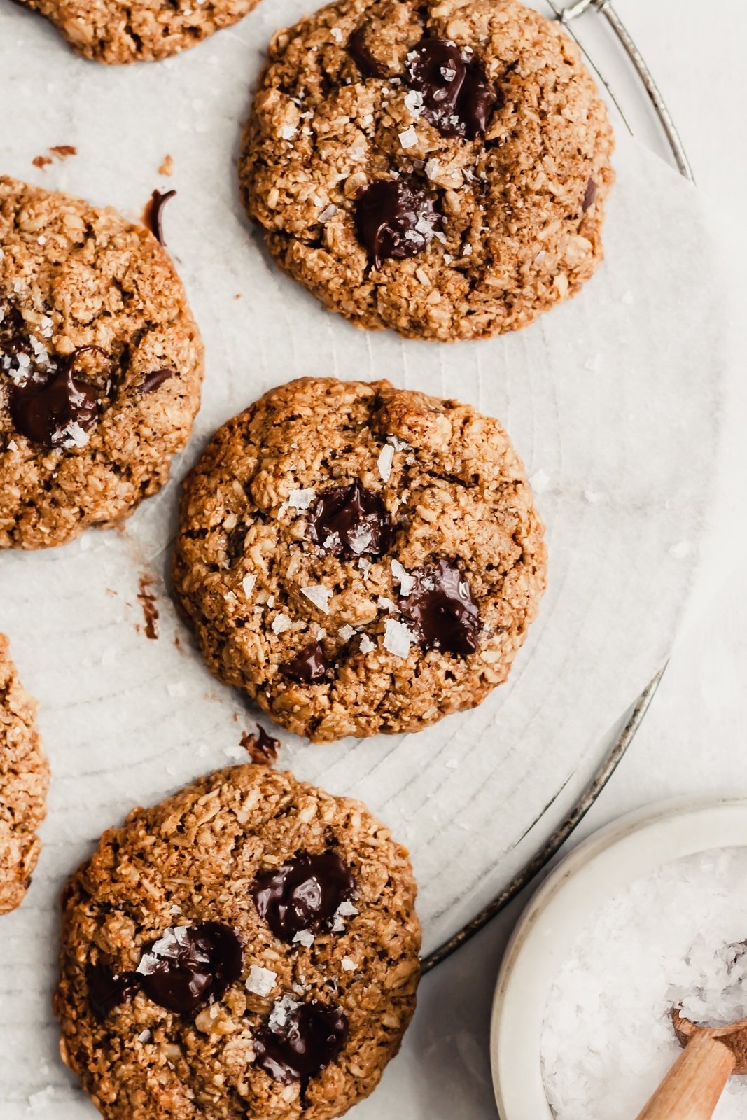 healthy chocolate chip cookies on a cooling rack with sea salt on the side